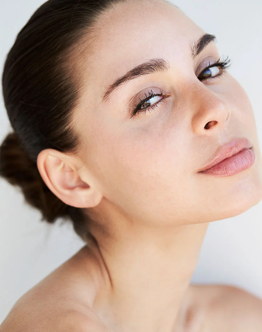 A close-up portrait of a woman with shoulder-length dark brown hair in a low bun. She is angled to the right, glancing into the camera. - Pixel 8 RF in Los Angeles, CA